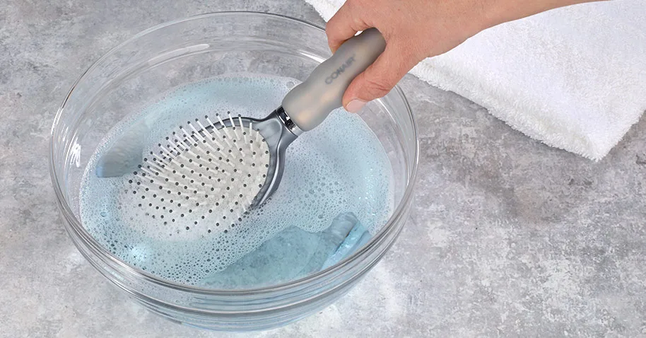 Soaking a hairbrush in warm soapy water